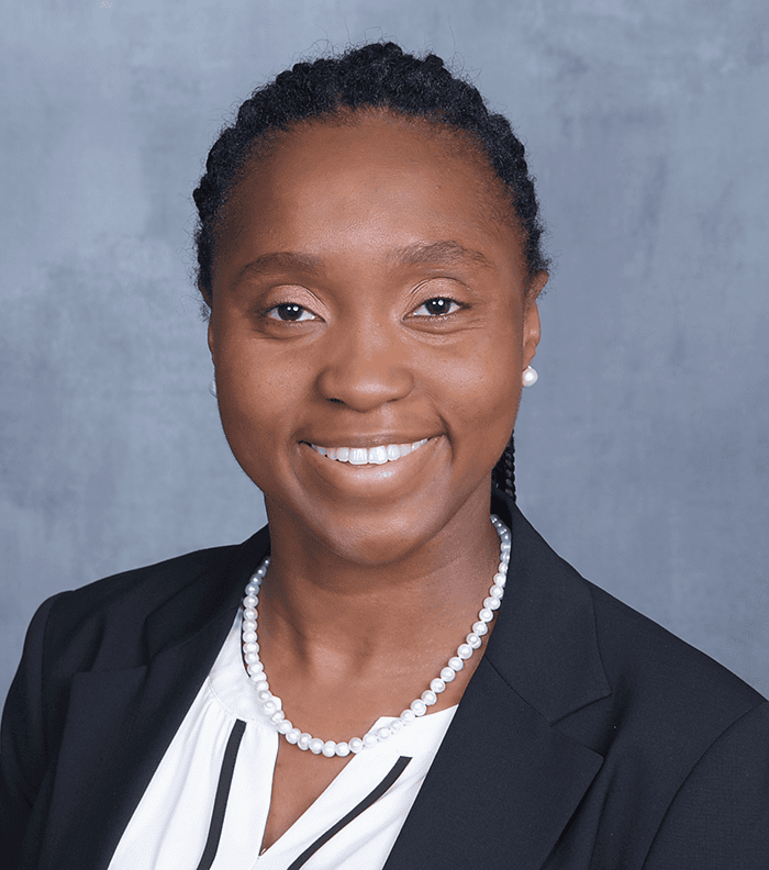 Professional woman speaker at SIIM Annual Meeting, delivering presentation on medical imaging innovations, wearing formal attire with a confident smile.