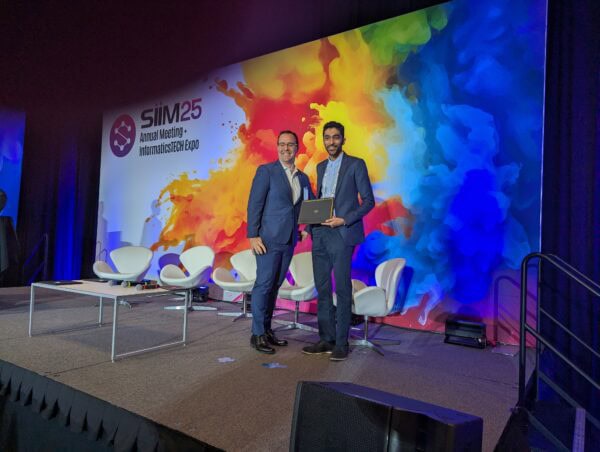 Innovative presentation at the SIIM Annual Meeting, showcasing advancements in medical imaging technology and informatics, with award recipient receiving recognition on stage.