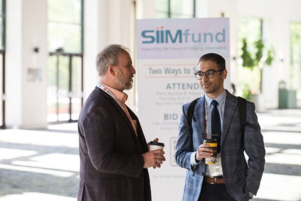 Conference attendees engaging at the SIIM Annual Meeting, showcasing radiology and medical imaging professionals networking and discussing innovations in imaging informatics.