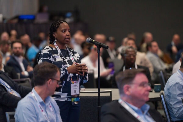 Diverse conference attendee speaking during the SIIM Annual Meeting, engaging in a professional discussion on medical imaging innovations and healthcare technology advancements.