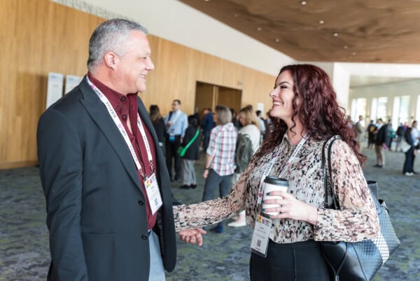 Professional conference attendees greeting each other at the SIIM Annual Meeting, a leading event in medical imaging, radiology, and health IT, showcasing networking and knowledge exchange opportunities.