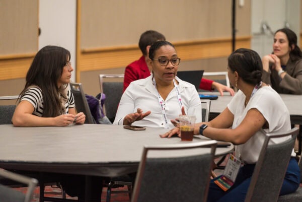 Advanced medical professionals engaging in discussion at the SIIM Annual Meeting, showcasing collaboration and networking in healthcare informatics and imaging innovation.