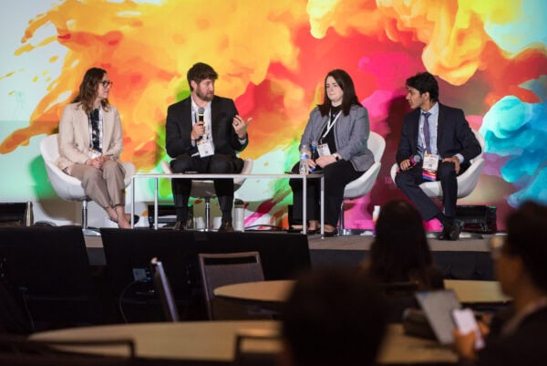 Innovative medical professionals discuss healthcare advancements at the SIIM Annual Meeting with a vibrant, colorful background.