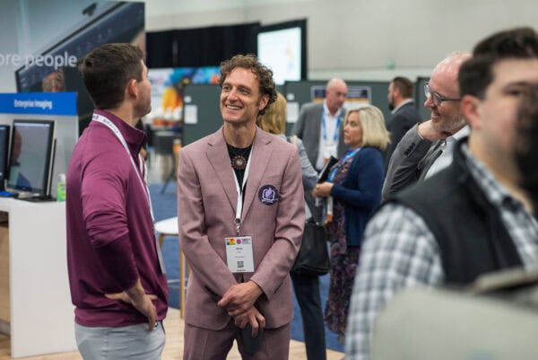 Networking at the SIIM Annual Meeting, healthcare professionals discussing medical imaging innovations and radiology advancements in a vibrant conference environment.