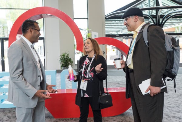 Professional networking at SIIM Annual Meeting, diverse healthcare professionals engaging in conversation in conference lobby, medical imaging, radiology innovation, SIIM event, healthcare technology discussion.