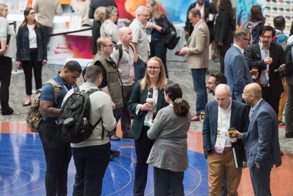Conference attendees engaging at the SIIM Annual Meeting, showcasing networking in a vibrant expo setting with radiology and medical imaging professionals.