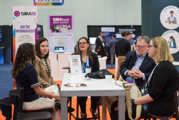 Flexible, multi-disciplinary healthcare professionals engaging at the SIIM Annual Meeting in a lively networking session focused on medical imaging innovation and informatics.