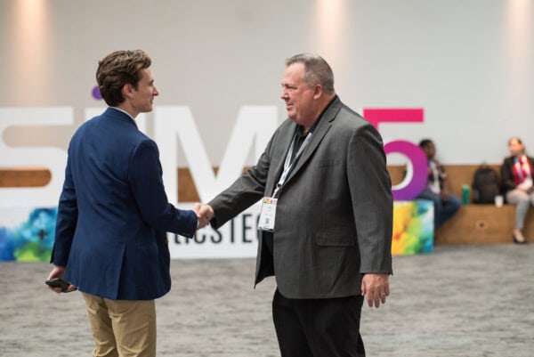 Handshake between two professionals at the SIIM Annual Meeting, emphasizing networking and collaboration in medical imaging.