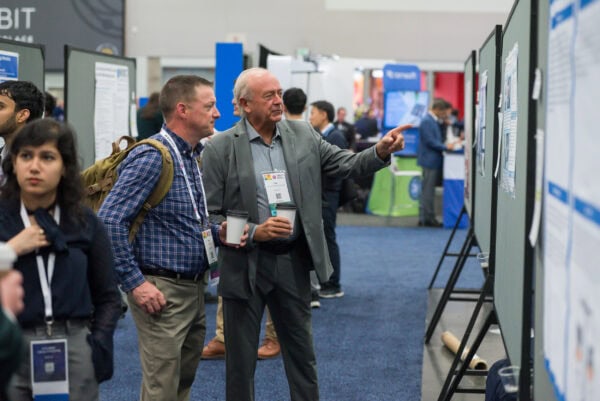 Advanced medical imaging professionals discussing research posters at the SIIM Annual Meeting, showcasing innovations in radiology and healthcare technology.