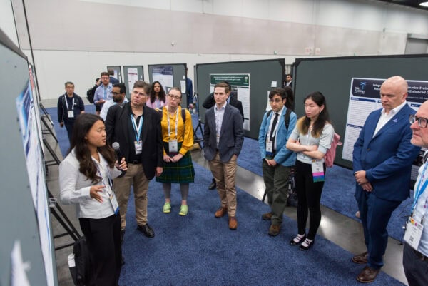 Innovative medical research presentation at SIIM Annual Meeting, participants discuss displaying advanced imaging technology and radiology case studies.