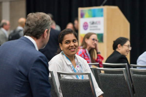 Diverse professionals attending the SIIM Annual Meeting engaging in conversations at a conference, emphasizing medical imaging, innovation, and collaboration in healthcare technology.