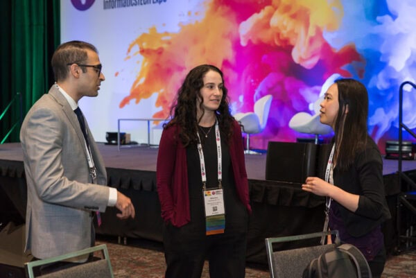 Innovative medical professionals networking at the SIIM Annual Meeting, engaging in discussions on healthcare IT and imaging informatics during the vibrant conference event.
