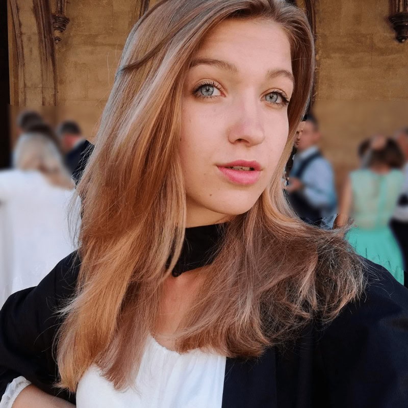 High-resolution portrait of a young woman with blue eyes and strawberry blonde hair at the SIIM Annual Meeting, showcasing attendees engaging in medical imaging and radiology innovations, vibrant event atmosphere.