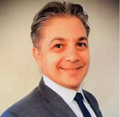 Professional portrait of a speaker at the SIIM Annual Meeting, showcasing a confident man in a suit, emphasizing medical imaging and healthcare innovation.