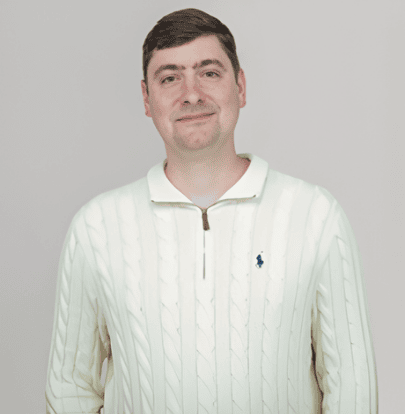 A young man smiling in a cream-colored sweater at the SIIM Annual Meeting, a leading event in medical imaging and informatics.