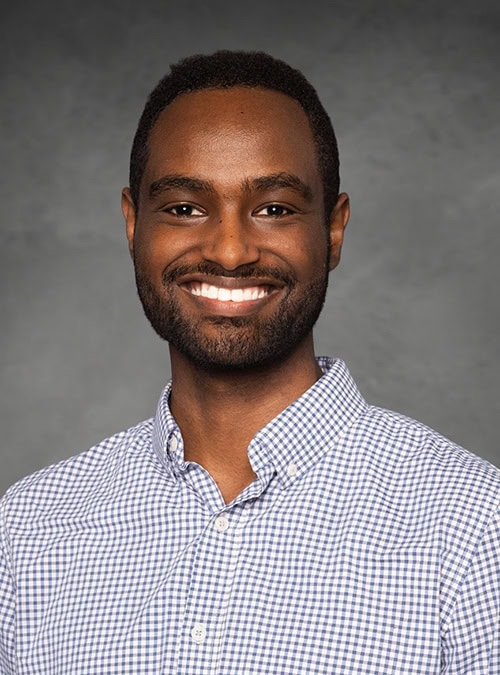 Portrait of Biniam Garomsa smiling at the SIIM Annual Meeting, showcasing professional attire and engaging presence in a conference setting.