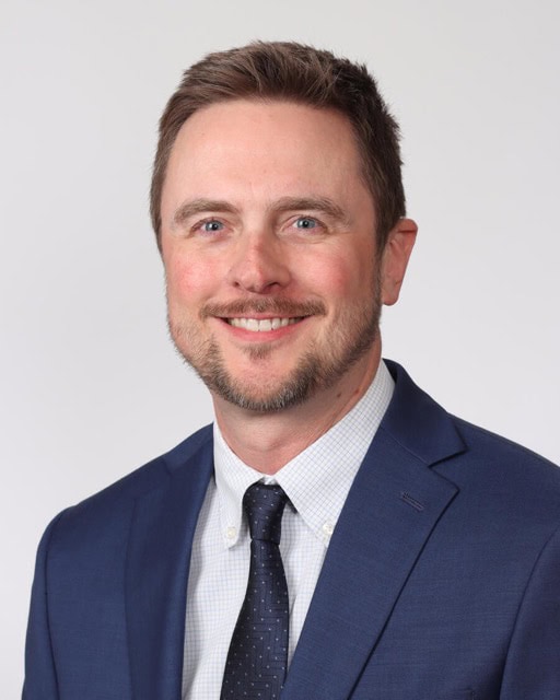 Professional headshot of Jason Klug, PhD, attending the SIIM Annual Meeting, showcasing a confident smile and business attire.
