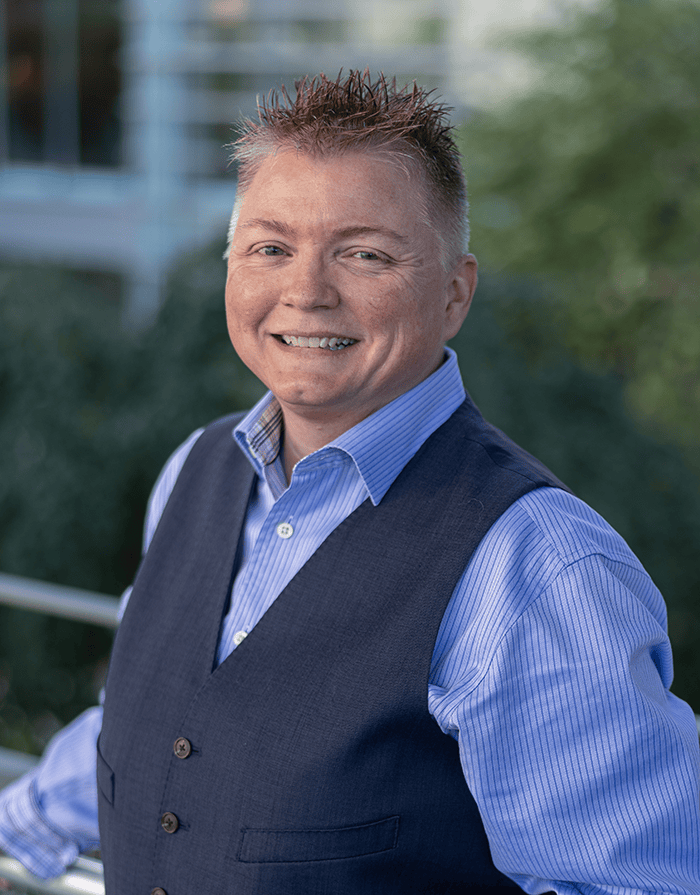An image of Tonya Edge, RT(R)(ARRT), CIIP, at the SIIM Annual Meeting, showcasing her expertise in medical imaging and radiology. She is smiling outdoors, dressed professionally, with a blurred backgr.