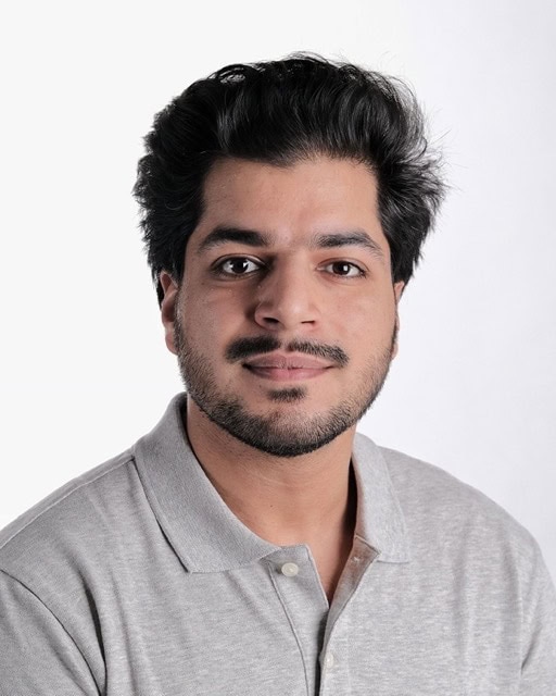 Professional portrait of a young man with dark hair and beard, wearing a light gray polo shirt, at the SIIM Annual Meeting, showcasing medical imaging and healthcare innovation.