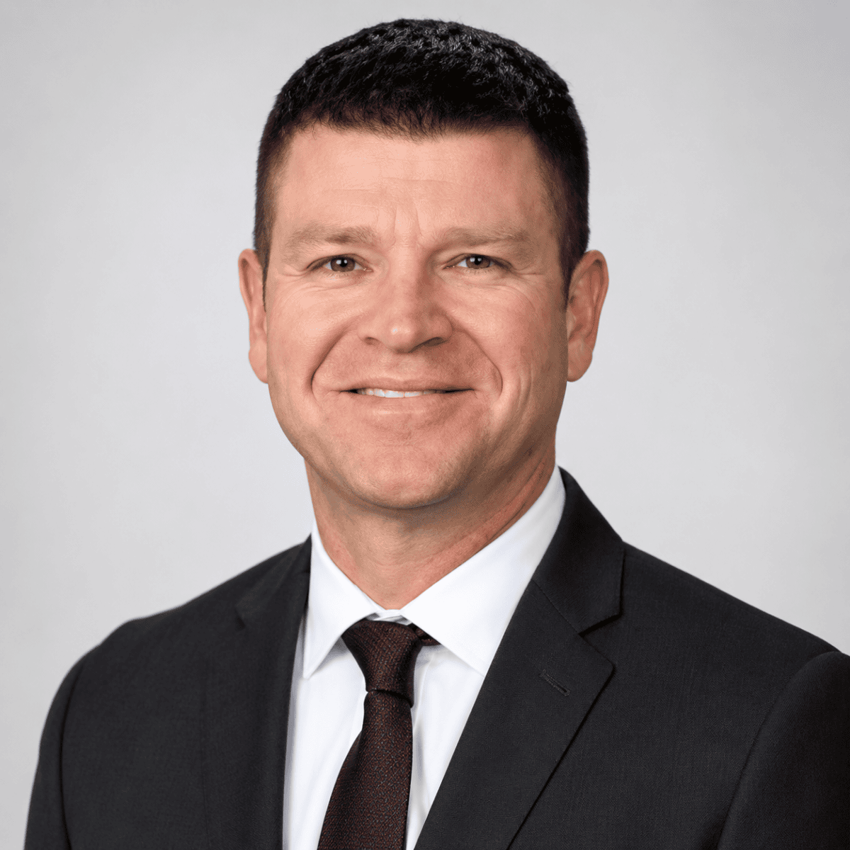 A confident male medical professional in a suit speaking at the SIIM Annual Meeting, engaging with healthcare and imaging technology professionals.