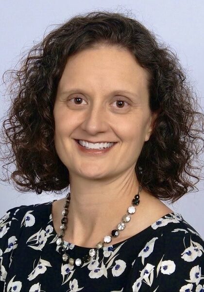 Professional woman speaker at SIIM Annual Meeting, engaging audience with presentation on medical imaging innovations, conference in progress.