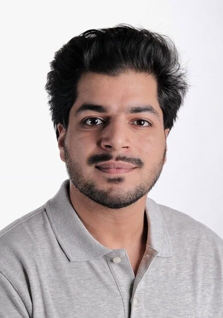 Professional portrait of a young man with dark hair and beard, wearing a light gray polo shirt, at the SIIM Annual Meeting, showcasing medical imaging and healthcare innovation.