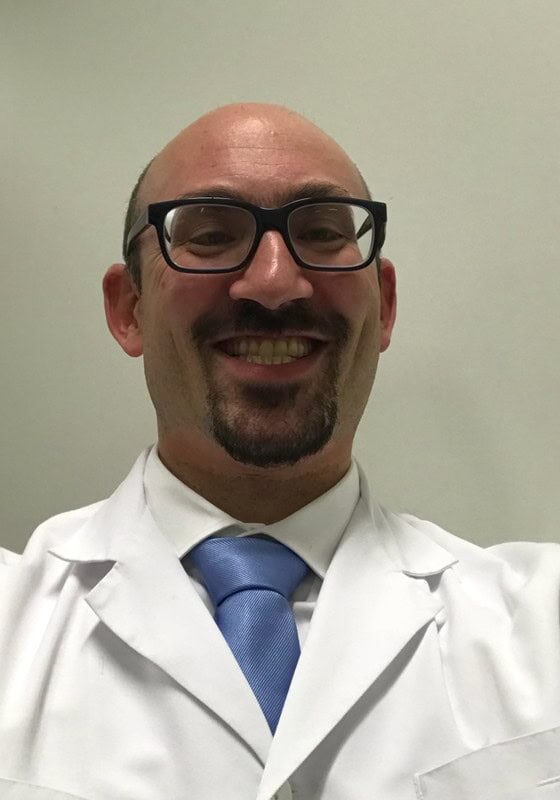 A healthcare professional in a white lab coat and blue tie, smiling at the camera at the SIIM Annual Meeting.