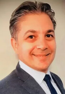 Professional portrait of a speaker at the SIIM Annual Meeting, showcasing a confident man in a suit, emphasizing medical imaging and healthcare innovation.