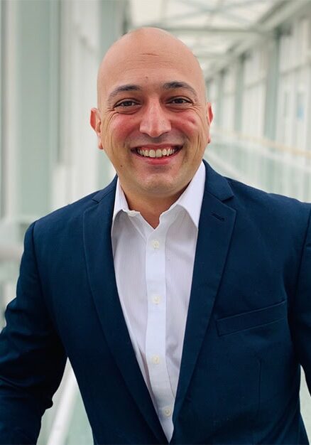 Shahab Taheri smiling at the SIIM Annual Meeting, showcasing professional attire and a confident demeanor in a modern conference setting.
